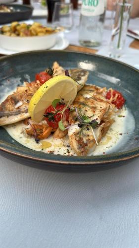 a plate of food with a lemon on a table at Alte Pfarrey in Neuleiningen