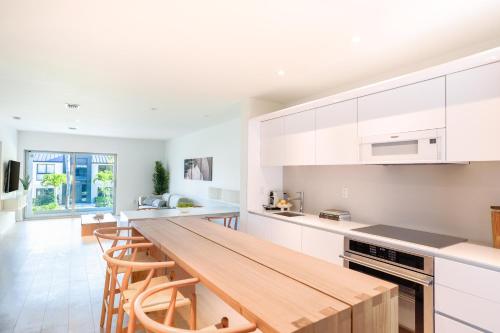 a kitchen with white cabinets and a wooden counter top at Beach Haus Key Biscayne Contemporary Apartments in Miami