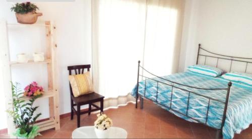 a bedroom with a bed and a chair and a table at LaGreka2025 in San Pantaleone