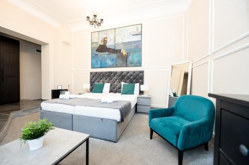 a bedroom with a bed and a blue chair at Boutique Hotel Kings Palace in Belgrade