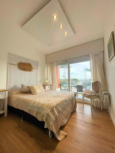 a bedroom with a bed and a large window at Encantador apto frente al mar in Punta del Este