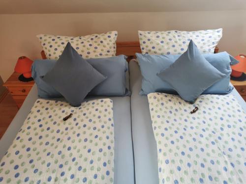 a bed with four pillows on top of it at Ferienwohnung Kerstin in Strackholt Ostfriesland- Urlaub in Großefehn 