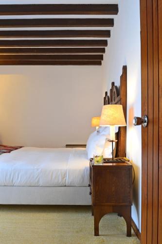 a bedroom with a bed and a table with a lamp at Pousada Geres-Caniçada in Geres
