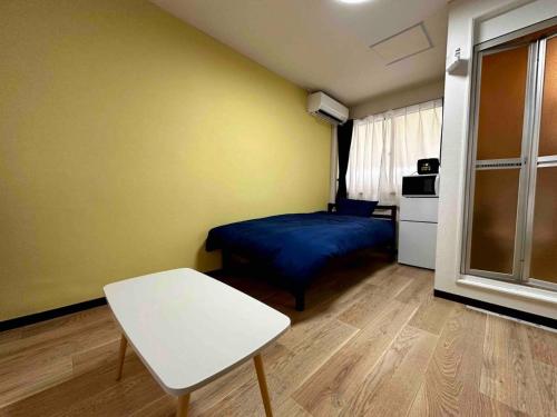 a small room with a bed and a table in it at Coop Sunlight - Vacation STAY 19686 in Sapporo
