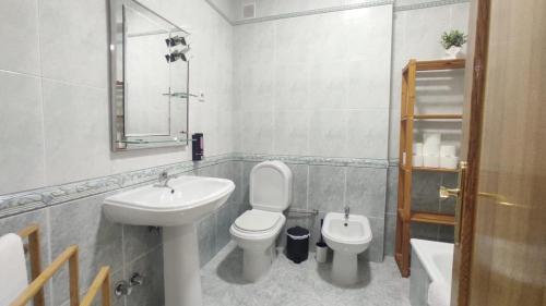 a white bathroom with a sink and a toilet at A&B Apartments - Afonso in Macedo de Cavaleiros
