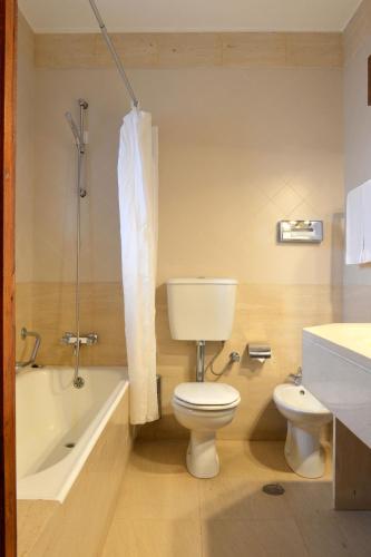 a bathroom with a toilet and a tub and a sink at Pousada Geres-Caniçada in Geres