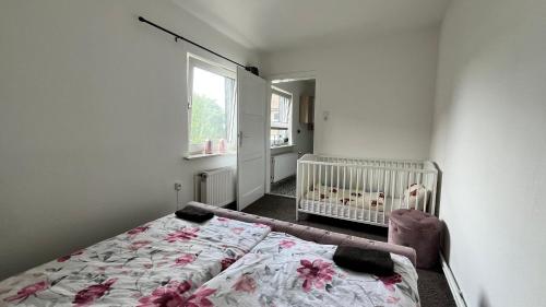 a bedroom with a crib and a bed in it at Ferienwohnung Harzgebirge in Goslar