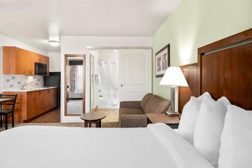 a hotel room with a bed and a living room at Ledgestone Suites Hotel Vernal in Vernal