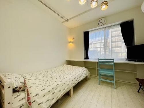 een slaapkamer met een bed, een stoel en een raam bij Cream Building - Vacation STAY 19747 in Sapporo