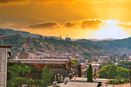 a view of a city with a rainbow in the sky at Hotel Tiflis Town in Tbilisi City