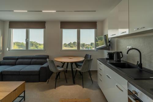 a kitchen and living room with a table and a couch at Elonea Villas, Luxury Villas and Studios in Kallikrateia Halkidiki with Garden, Veranda & BBQ in Nea Kalikratia