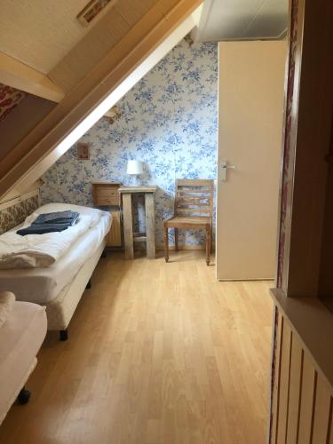 a bedroom with two beds and a table and a chair at Huisje Stockholm op Terschelling in West-Terschelling