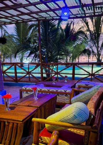 a restaurant with a table and chairs and palm trees at Kidoti Bay in Kidoti