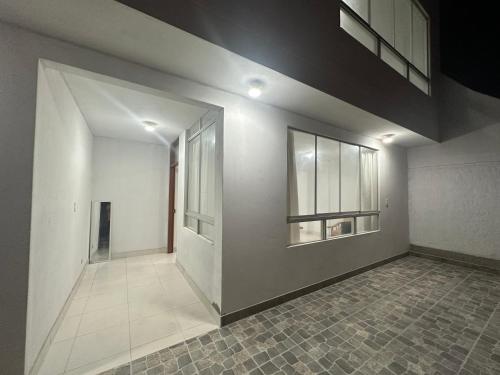 una stanza vuota con pareti bianche e pavimento piastrellato di RELAX Y PISCINA con vista al MAR - DUPLEX a Cerro Azul