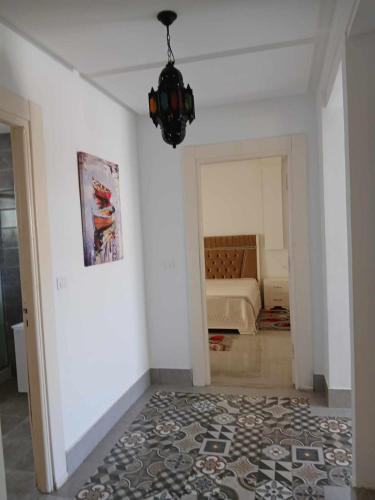 a room with a bed and a chandelier at Hébergement Zahra plage kelibia in Ḩammām al Ghazzāz