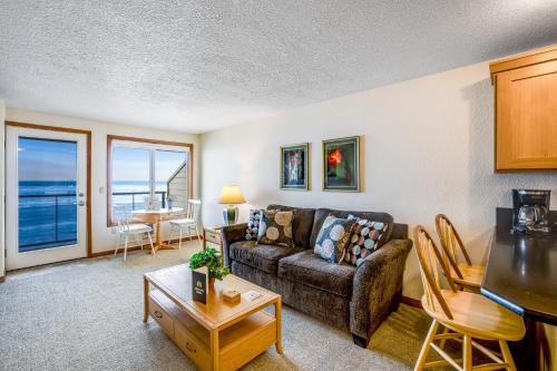 a living room with a couch and a table at Beachy View at Rock Creek Inn in Rockaway Beach