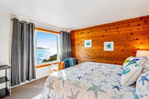 a bedroom with a bed with a wooden wall at Whale-come Home in Depoe Bay