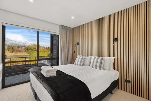 a bedroom with a large bed and a large window at Wanaka Ridge in Wanaka