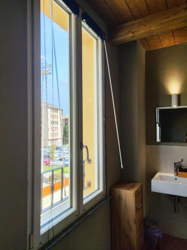 a bathroom with a large window and a sink at La Casetta Guest House 1 in Biella