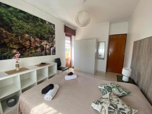 a bedroom with a bed and a large painting on the wall at On the way!* in Portimão