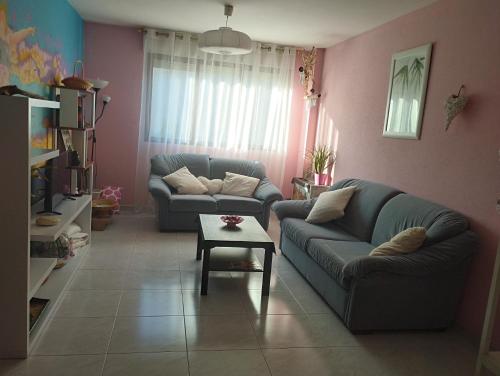 a living room with two couches and a table at Rincón de descanso in Ponferrada