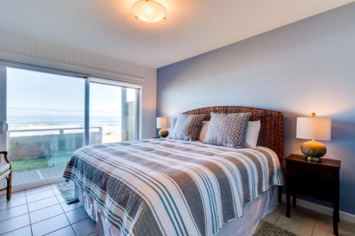 a bedroom with a bed with a view of the ocean at Pacific Sands Unit #10 in Neskowin