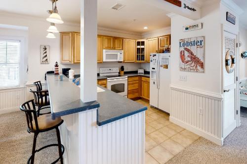 a kitchen with white appliances and a blue counter top at Sandy Cheeks #D2SC-H in Hatteras