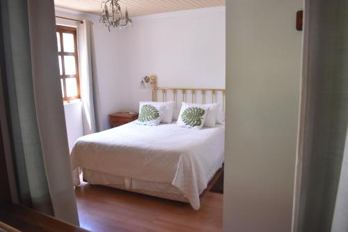 a bedroom with a white bed with two pillows at Hostal Pando in Santa Cruz