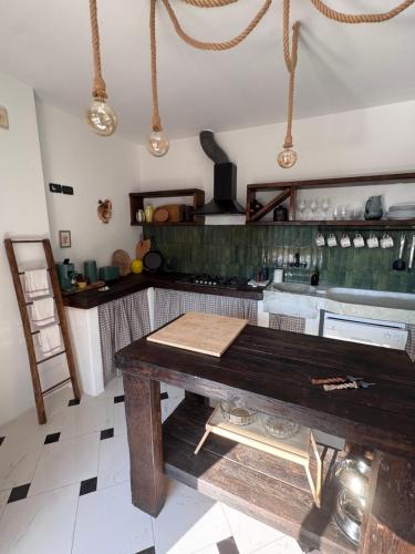 a kitchen with a wooden table in a room at La Casa negli Ulivi - con vista Mare in Arnasco