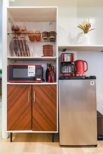 a kitchen with a refrigerator and a microwave at 7even Clouds Éclair- Cozy basement nest near NE DC in Hyattsville