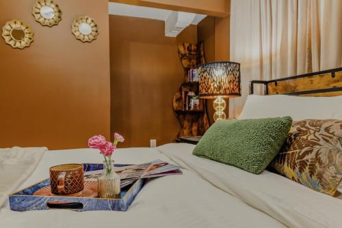 a bed with a tray on it with flowers on it at 7even Clouds Éclair- Cozy basement nest near NE DC in Hyattsville
