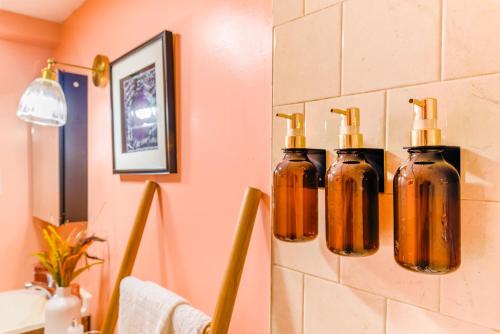 a bathroom with four bottles on a wall at 7even Clouds Éclair- Cozy basement nest near NE DC in Hyattsville