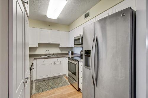 a kitchen with white cabinets and a stainless steel refrigerator at Turn Of River 2F in Folly Beach