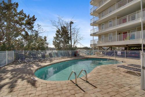 a swimming pool in front of a building at Turn Of River 2F in Folly Beach