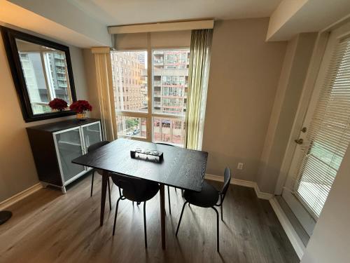 a dining room with a table and chairs and a window at Large Downtown 2Br condo with Parking steps to Eaton Centre, UofT and SickKids in Toronto