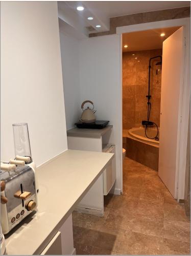 a bathroom with a white counter with a sink and a tub at Stylish studio 3-4p with AC and balcony near Champs-Élysées in Paris