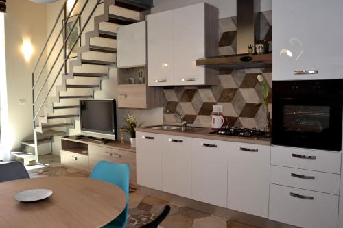 ナポリにあるSan Biagio, 25 Apartment Aの白いキャビネットとらせん階段付きのキッチン