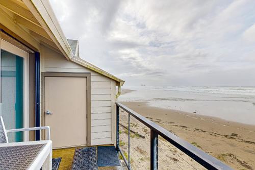 a house with a door on the beach at On The Sand in Rockaway Beach