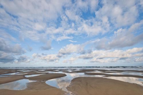 a large body of water under a cloudy sky at On The Sand in Rockaway Beach