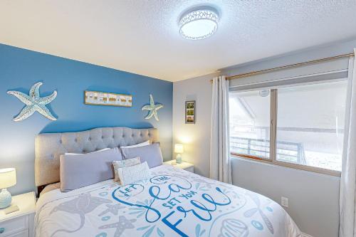 a bedroom with a bed with a blue wall at On The Sand in Rockaway Beach