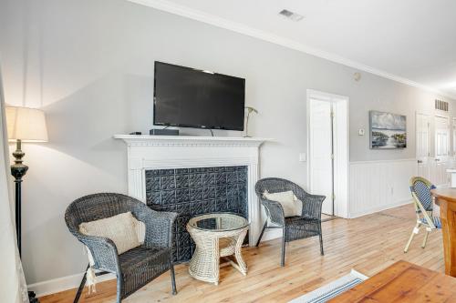 a living room with three chairs and a fireplace at Marsh Winds 2K in Folly Beach