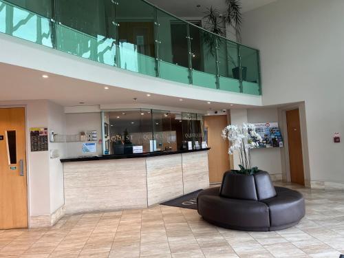 a lobby with a black ottoman in a building at Littoral Living in Tauranga