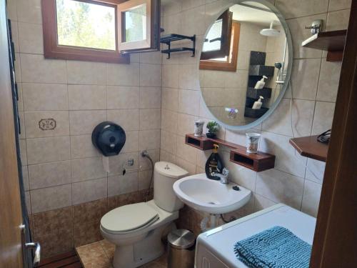a bathroom with a toilet and a sink and a mirror at SeaSaos in Samothráki