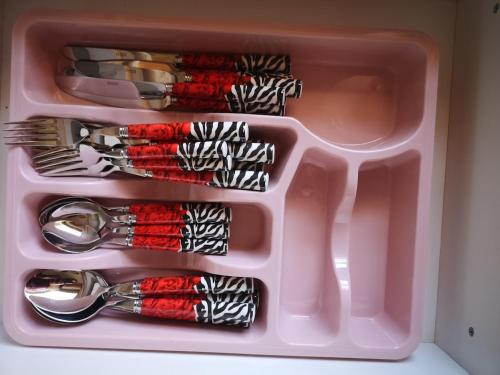 a pink container filled with forks and spoons at Spacious Family-Friendly 2BR Flat Near City Center in Alexandroupoli
