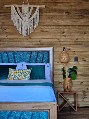 a bedroom with a blue bed and a wooden wall at Beach Suite cerca al Tayrona in Santa Marta