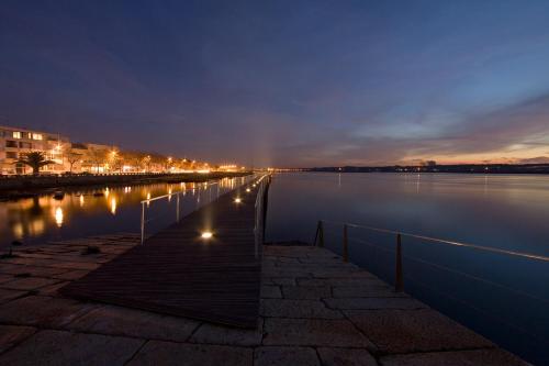 a river at night with lights reflecting on the water at Esposende 3 Bedrooms Balcony Center Flat in Esposende
