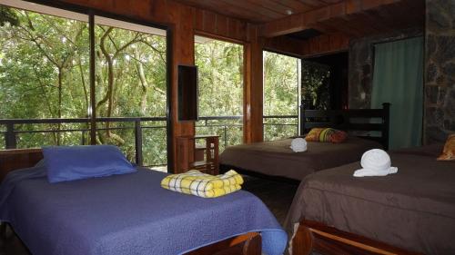 Postel nebo postele na pokoji v ubytování Manakin Lodge, Monteverde