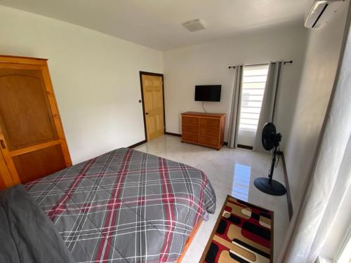 a bedroom with a bed and a dresser and a television at Glenvilla in Bank Level