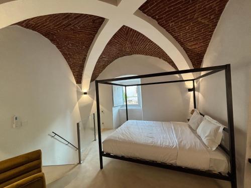 a bedroom with a bed with a brick ceiling at QO - Terrace Suites in Vila Viçosa