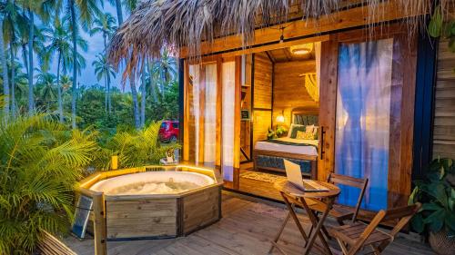 a hot tub on a deck with a bed and a bedroom at Beach Suite cerca al Tayrona in Santa Marta